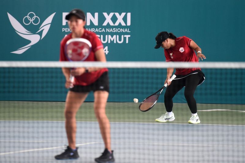 Petenis ganda putri DKI Jakarta Siti Nur Arasy (kanan) dan Julia Sanger (kiri) mengembalikan bola ke pasangan Jawa Barat Beatrice dan Dwi Rahayu pada pertandingan final soft tenis PON XXI Aceh-Sumut 2024 di Lapangan Soft Tenis Trengginas, Mapolda Banda Aceh, Aceh, Minggu (15/9/2024). Pasangan ganda putri DKI Jakarta berhasil mengalahkan Jawa Barat dengan skor 5-4. ANTARA FOTO//Budi Candra Setya/pras. (ANTARA FOTO/Budi Candra Setya)