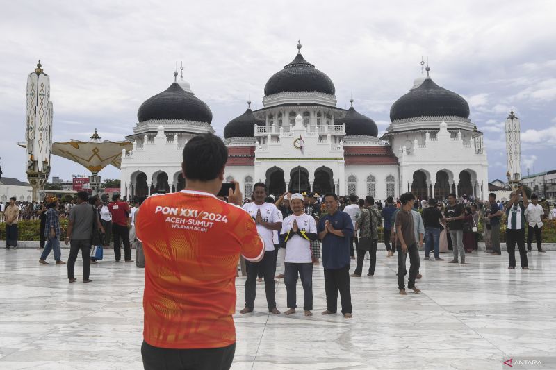 Pengunjung berswafoto di halaman Masjid Raya Baiturrahman Banda Aceh, Aceh, Jumat ( 13/9/2024). ANTARA FOTO/Adeng Bustomi/pras. (