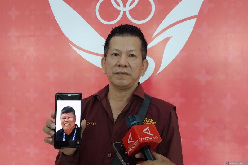 Pebiliar Aceh Winoto berfoto sambil menunjukkan foto sahabatnya (almarhum Teuku Bustaman) kepada awak media usai memenangkan laga final untuk meraih medali emas nomor 9 ball single putra cabang biliar PON Aceh-Sumut 2024 di Pardede Hall, Medan, Kamis (19/9/2024). (ANTARA/Aloysius Lewokeda)