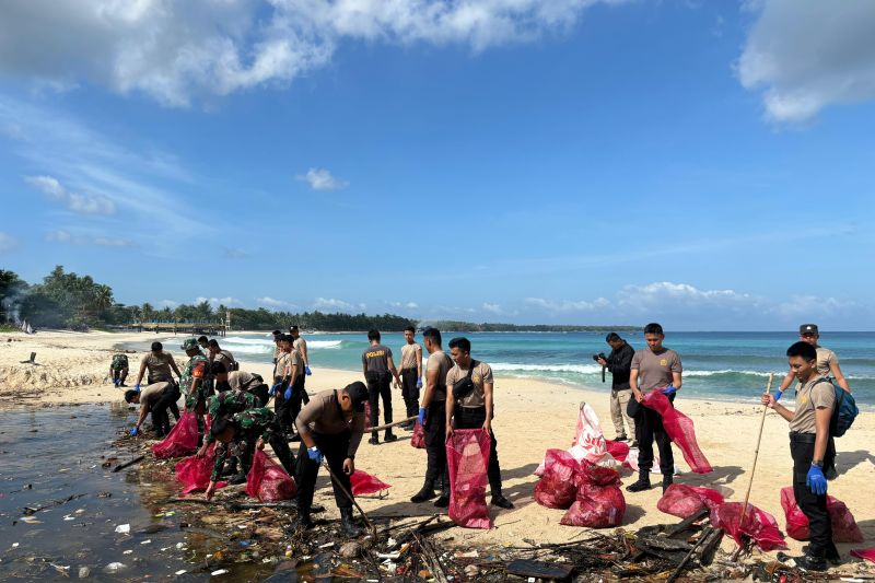 Sejumlah anggota Kepolisian Polres Pesisir Barat, Anggota Kodim dan komunitas serta warga melakukan aksi bersih sampah di Pantai Labuhan jukung. (ANTARA/HO/Humas Polres Pesisir Barat)