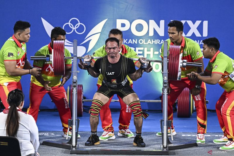 Lifter Jawa Barat Ade Bazrudin melakukan angkatan squat pada perlombaan angkat berat kelas 74 kg putra PON XXI Aceh-Sumut 2024 di GOR Seuramoe Angkat Besi Stadion Harapan Bangsa, Banda Aceh, Aceh, Selasa (17/9/2024). Lifter Riau Hendri berhasil meraih medali emas dengan total angkatan 765 kg sedangkan medali perak diraih oleh lifter Jawa Barat Ade Bazrudin dengan total angkatan 760 kg dan medali perunggu diraih lifter Jawa Tengah Adven Hindarto dengan total angkatan 690 kg. ANTARA FOTO/Aprillio