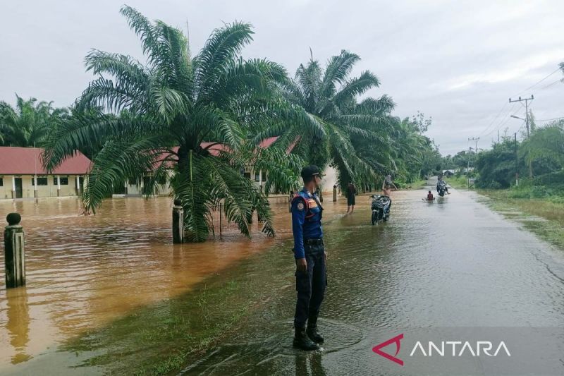 Petugas melakukan pemantauan di depan SDN Napai, Kecamatan Woyla Barat, Kabupaten Aceh Barat yang mulai terendam air akibat tingginya curah hujan. Hingga Jumat (20/9/2024) sebagian besar wilayah Aceh Barat dan Nagan Raya Aceh masih terus dilanda hujan lebat. (ANTARA/HO-Pemkab Aceh Barat)