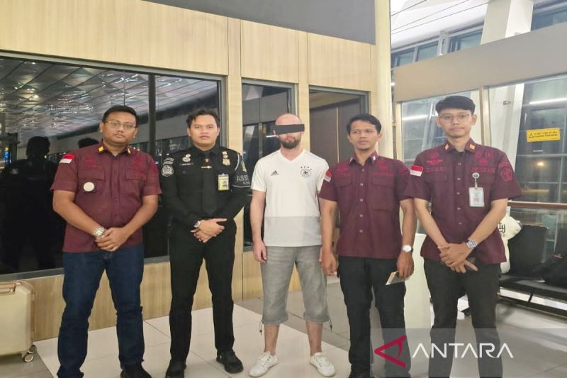 Petugas Kantor Imigrasi Kelas II TPI Batulicin mengawal proses deportasi seorang WNA asal Algeria berinisial BS (kaos putih) di Bandara Soekarno-Hatta. (ANTARA/Firman)