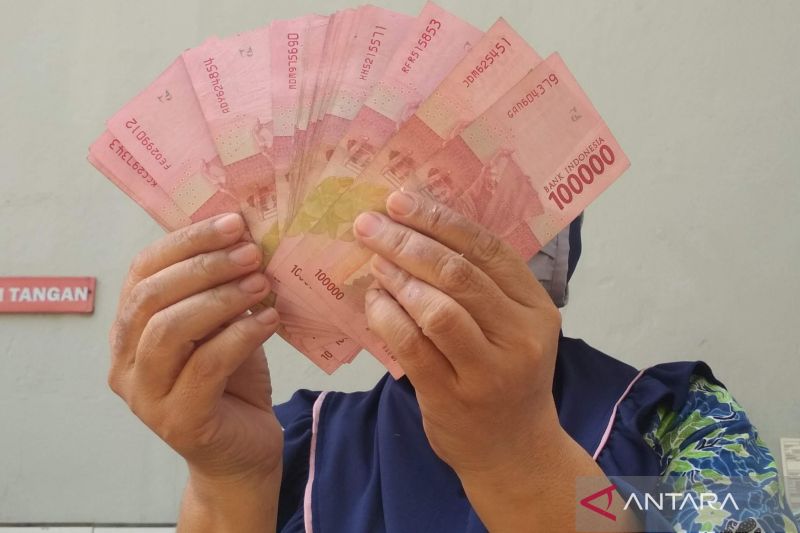 Seorang pekerja rokok menunjukkan uang pecahan Rp100 ribuan. Mereka kini mendapatkan program bantuan langsung tunai (BLT) dari Pemkab Demak, selain pula para buruh tani tembakau. (ANTARA/Akhmad Nazaruddin Lathif)