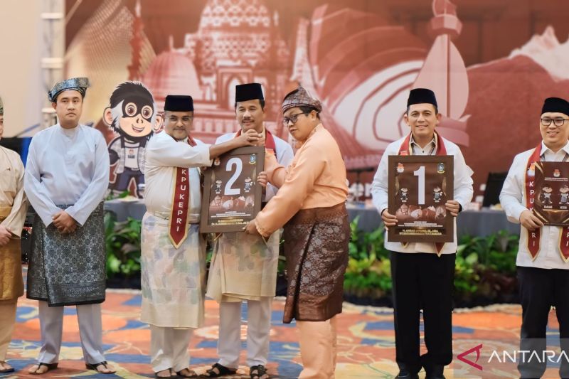 Ketua KPU Kepri Indrawan Susilo Prabowoadi menyerahkan plakat nomor urut kepada dua paslon gubernur dan wakil gubernur di TCC Aston Hotel Tanjungpinang, Senin (23/9/2024). (ANTARA/Ogen)