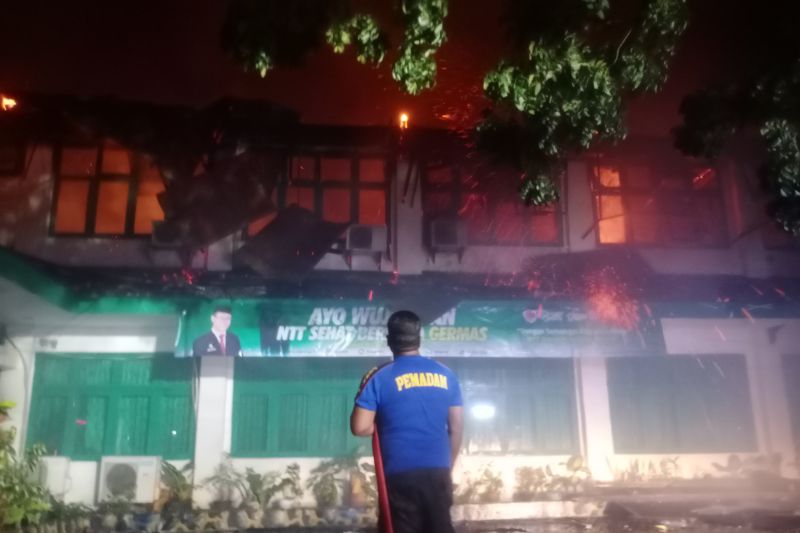 Seorang petugas pemadam kebakaran sedang berusaha memadamkan api yang membakar kantor Dinas Kesehatan NTT. ANTARA/Kornelis Kaha.