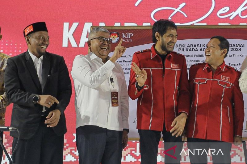 Dua calon Gubernur Aceh, Bustami (putih) dan Muzakir Manaf (merah) saling memperagakan nomor urut lewat tangan masing-masing saat deklarasi damai Pilkada 2024, di Aceh Besar, Selasa malam (25/9/2024). ANTARA FOTO/Khalis Surry