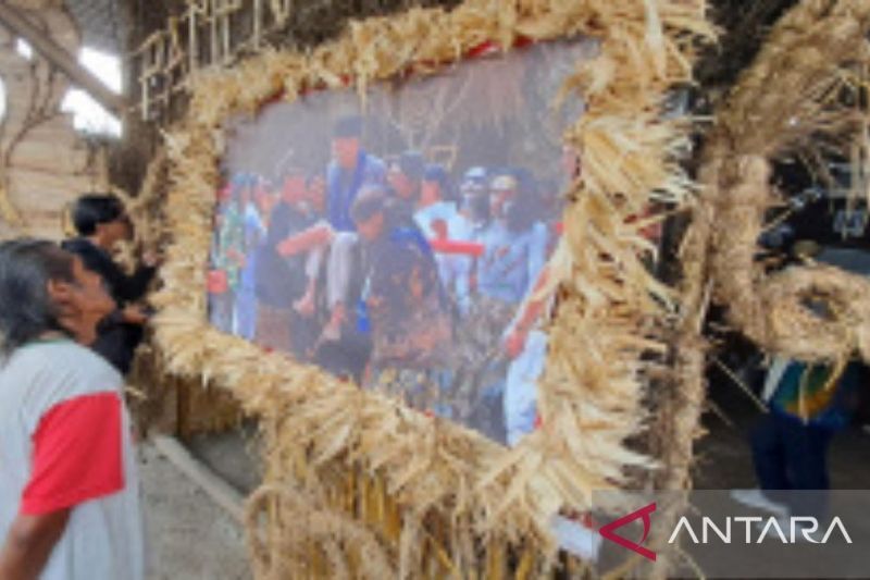 Seorang warga menonton salah satu foto karya kelompok fotografer "Rencang Lima Gunung Ring Setengah" dalam pameran foto pada Festival Lima Gunung XXIII/2024 di Dusun Keron, Desa Krogowanan, Kecamatan Sawangan, Kabupaten Magelang, Jateng, Rabu (25/9/2024). ANTARA/Hari Atmoko