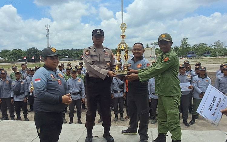 Penyerahan piala juara umum dalam Jambore Satlinmas se Kabupaten Kobar pada perwakilan Kecamatan Pangkalan Banteng, dalam penutupan kegiatan tersebut, Kamis, 26 September 2024. (FOTO: IST)