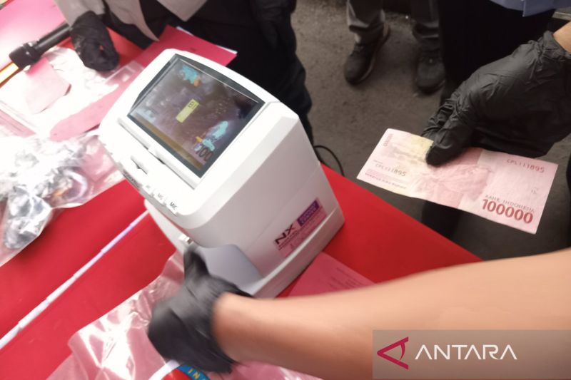 Petugas saat mempraktikan pengecekan uang menggunakan alat money detector dalam konferensi pers di Mapolresta Cirebon, Jawa Barat, Kamis (26/9/2024). ANTARA/Fathnur Rohman.