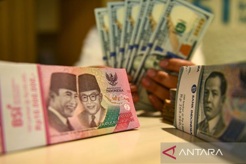 Ilustrasi - Petugas perbankan menunjukan uang pecahan dolar AS dan rupiah. ANTARA FOTO/Muhammad Adimaja/Spt/aa.