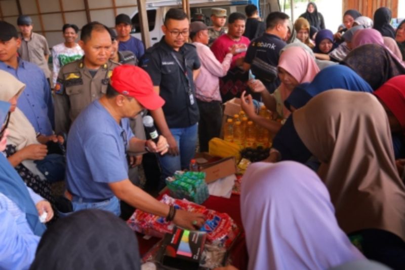 Pj Bupati H Syamsir Rahman (topi merah) bersama Pj Ketua Tim Penggerak PKK Tala Hj Rizki Yulia Syamsir Rahman saat ikut terjun langsung melayani masyarakat yang berbelanja di pasar murah. (ANTARA/HO-Diskominfo Tanah Laut)