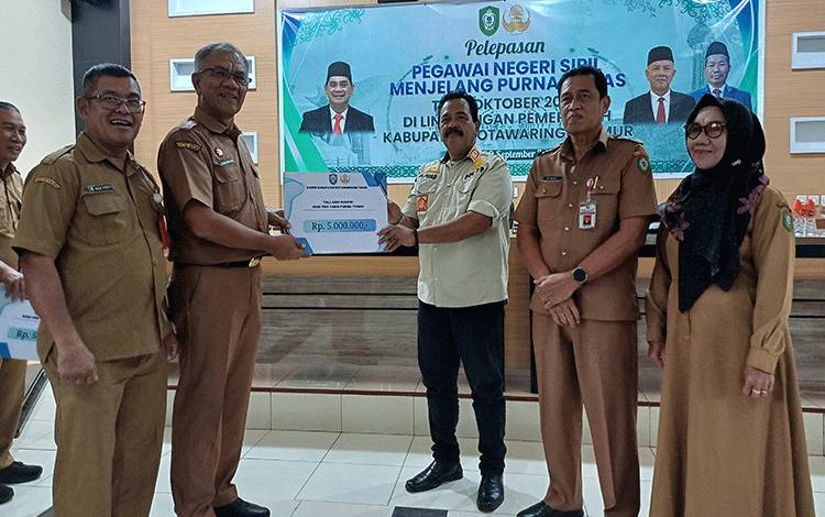 Pj Sekretaris Daerah Kotawaringin Timur Sanggul Lumban Gaol menyerahkan SK pensiun untuk Fuad Sidiq dan Muhammad Yusuf, Senin, 30 September 2024. (FOTO: DEWI)