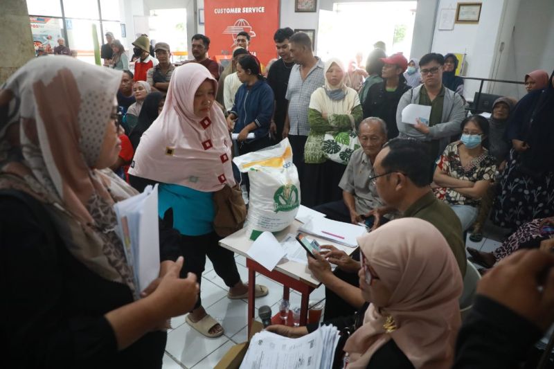 Ilustrasi - Sejumlah warga Kota Madiun yang masuk data miskin antre menerima bantuan pangan dari pemerintah. ANTARA/HO-Diskominfo Kota Madiun
