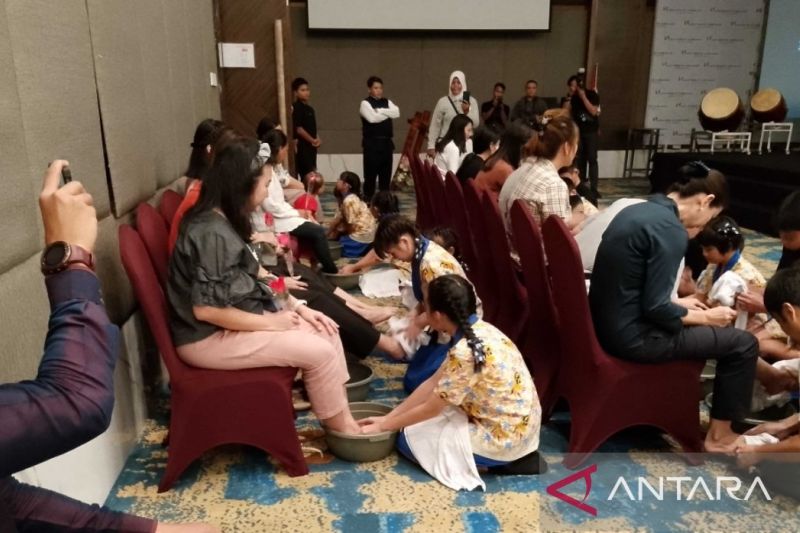 Anak di Kabupaten Biak Numfor, Papua membasuh kedua telapak kaki ibu dan bapak sebagai wujud kasih sayang terhadap jasa orang tua yang membesarkan anak.ANTARA/Muhsidin (foto)