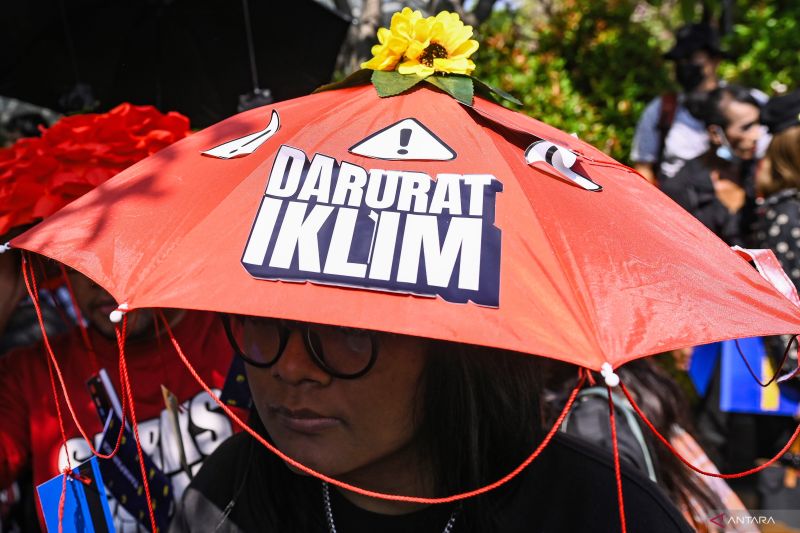 Arsip - Seorang aktivis memakai topi payung aspirasi saat mengikuti aksi Darurat Iklim di Jakarta, Jumat (27/9/2024). (ANTARA FOTO/Sulthony Hasanuddin/foc.c).