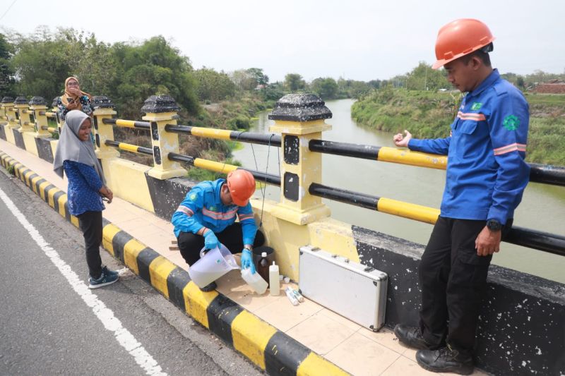 Petugas Dinas Lingkungan Hidup (DLH) Kota Madiun mengambil sampel air Sungai Bengawan Madiun dari titik Jembatan Prambanan, Jumat (4/10/2024). ANTARA/HO-Diskominfo Kota Madiun