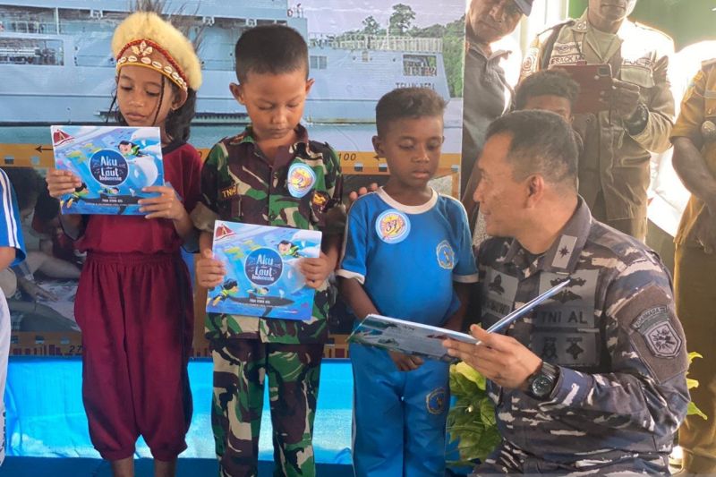 Komandan KRI Teluk Weda 526 Letkol Laut (P) Ricky Tacomariyanto (paling kanan) menularkan budaya membaca kepada anak-anak di Papua. ANTARA/HO-KRI Teluk Weda 526