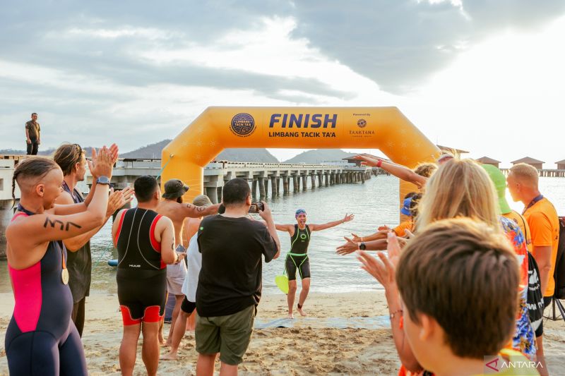 Peserta kompetisi renang perairan terbuka Limbang Tacik Ta'a kategori Master 5000 m menyambut finisher Di area Pantai Ta'aktana Labuan Bajo, Nusa Tenggara Timur, Sabtu (5/10/2024). (ANTARA/HO/LIMBANG TACIK 2024)