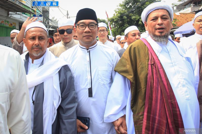 Calon Gubernur DKI Jakarta nomor urut satu, Ridwan Kamil (tengah) bergandengan dengan pengasuh Majelis Taklim Al-Habsyi Kwitang Jakarta Habib Ali bin Abdurrahman Al-Habsyi (kanan) berserta sejumlah ulama lainnya dalam acara Maulid Akhir Kamis ke-104 di Kwitang, Jakarta, Kamis (3/10/2024). ANTARA FOTO/Reno Esnir/app/aww (ANTARA FOTO/RENO ESNIR)