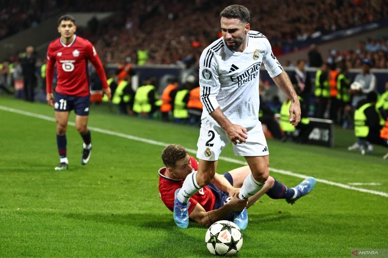 Bek Real Madrid Dani Carvajal (depan) saat berebut bola dengan bek Lille Gabriel Gudmundsson pada pertandingan Liga Champions di Stadion Pierre Mauroy di Villeneuve-d'Ascq, Prancis, 2 Oktober 2024. (AFP/SAMEER AL-DOUMY)