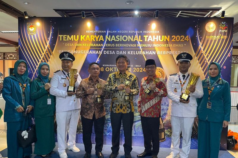 Lurah Karang Pule,Kota Mataram Arizkiawan Marjun (baju putih kanan) menerima Piala dan Piagam Penghargaan sebagai Juara 1 Nasional di Regional IV meliputi wilayah Nusa Tenggara, Maluku dan Papua yang diserahkan langsung oleh Bapak Dirjen PMD Kemendagri dan Wali Kota Mataram sebagai Pembina Kelurahan Terbaik yang diterima oleh Asisten 1 Setda Kota Mataram H Lalu Martawang (batik oranye) di Bali, Selasa (8/10/2024). (ANTARA/HO-Dokumen Pribadi)
