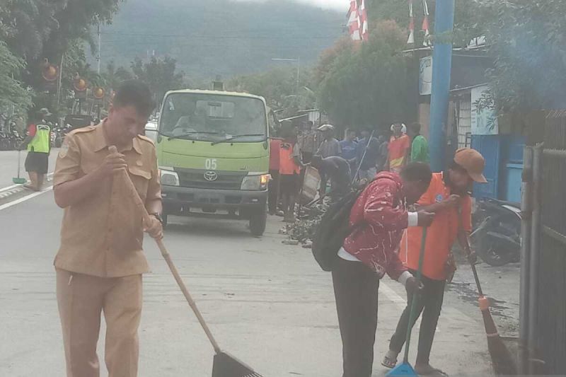 Petugas kebersihan Dinas Lingkungan Hidup Kabupaten Jayapura saat melakukan pembersihan di jalan protokol Sentani daerah setempat. (ANTARA/Yudhi Efendi)