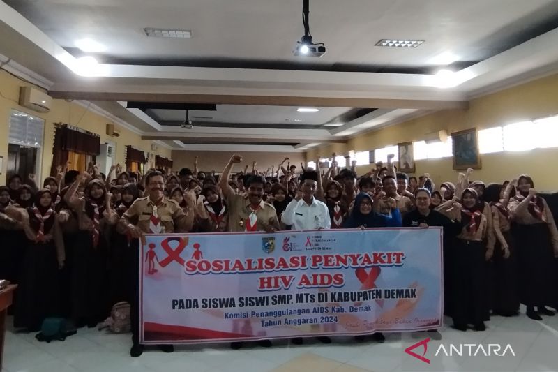 Sekretaris Daerah Kabupaten Demak Akhmad Sugiharto berfoto bersama Kepala SMP Negeri 2 Demak dan para siswa yang mengikuti sosialisasi bahaya HIV/AIDS di aula SMP Negeri 2 Demak, Jumat (11/10/2024). (ANTARA/Akhmad Nazaruddin Lathif)