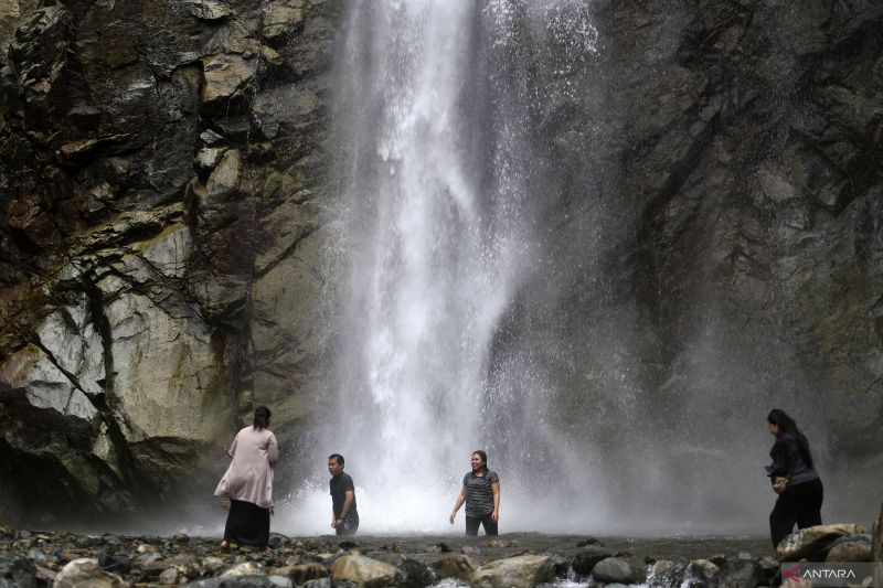 Arsip - Sejumlah pengunjung mandi di bawah air terjun Permai Taludaa, Kecamatan Bone, Kabupaten Bone Bolango, Gorontalo, Rabu (9/10/2024). Air terjun dengan ketinggian 42 meter tersebut menjadi salah satu destinasi wisata alam unggulan di wilayah perbatasan Provinsi Gorontalo dan Sulawesi Utara. ANTARA/Adiwinata Solihin