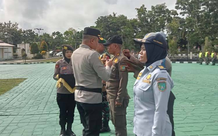 Kapolres Sukamara AKBP Telly Alvin memasang pita kepada apersonil tanda dimulainya Operasi Zebra Telabang 2024 di Wilayah Kabupaten Sukamara, Senin, 14 Oktober 2024. (FOTO: NORHASANAH)