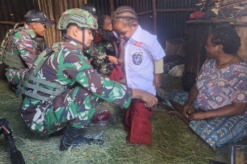 Prajurit Yonif 641/Bru membagikan seragam ke anak-anak di kampung Eroma, Distrik Kurima, Kabupaten Yahukimo, Provinsi Papua Pegunungan. (ANTARA/HO-Pendam XVII Cenderawasih)