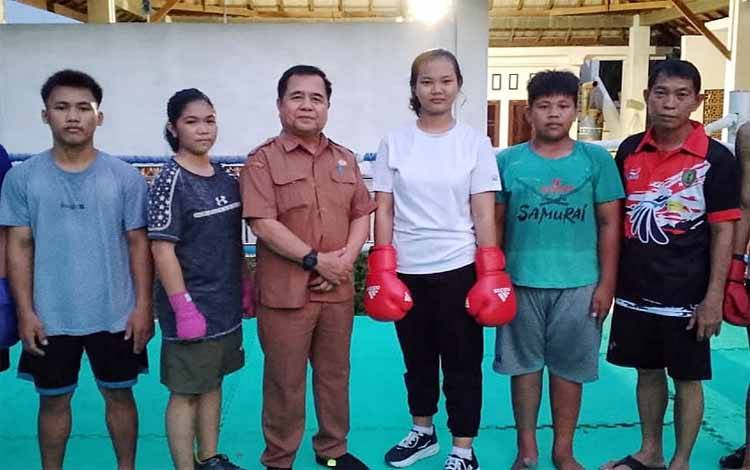 Efi Hasana Tunisa (kaos putih), berfoto dengan Ketua Pertina Kabupaten Barito Timur, Lurikto. Efi saat ini sedang menjalani pemusatan latihan di Palangka Raya, untuk berlaga di Pra Popnas Zona III di Solo Jawa Tengah, 11-18 Move 2024. (FOTO: AGUSTINUS BOLE MALO)