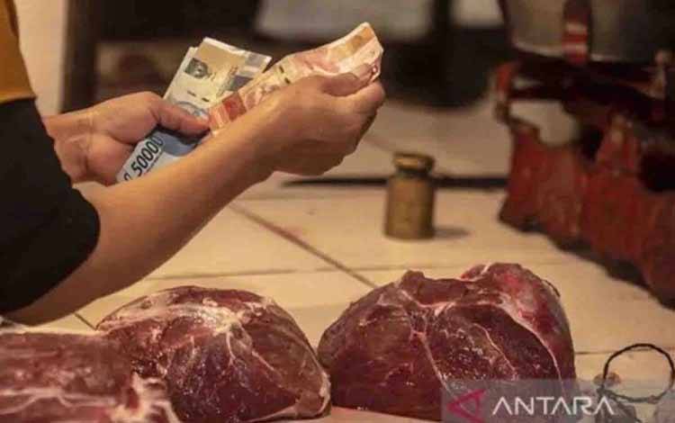 Pembeli membayar daging sapi kepada penjual di PD Pasar Jaya Kramat Jati, Jakarta, Minggu (27/2/2022). ANTARA FOTO/Muhammad Adimaja