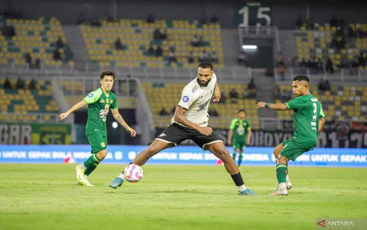 Pemain PSM Makassar Yuran Fernandes (tengah) berebut bola dengan pemain Persebaya Ardi Idrus (kanan) saat pertandingan pekan kesembilan BRI Liga 1 Indonesia di Stadion GBT Surabaya, Rabu (23/10/2024) malam. (ANTARA FOTO/Rizal Hanafi)