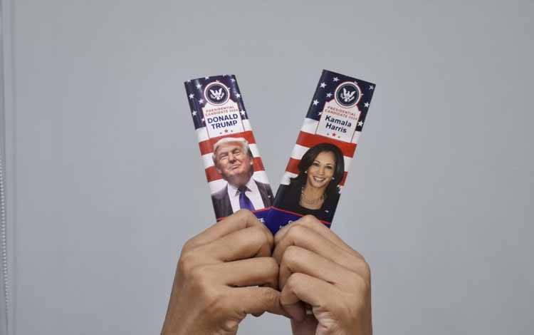 Ilustrasi Pemilihan Presiden Amerika Serikat (AS). Tangan memegang dua batang cokelat dengan wajah kandidat presiden AS Donald Trump dan Kamala Harris. (ANTARA/Yuni Arisandy)