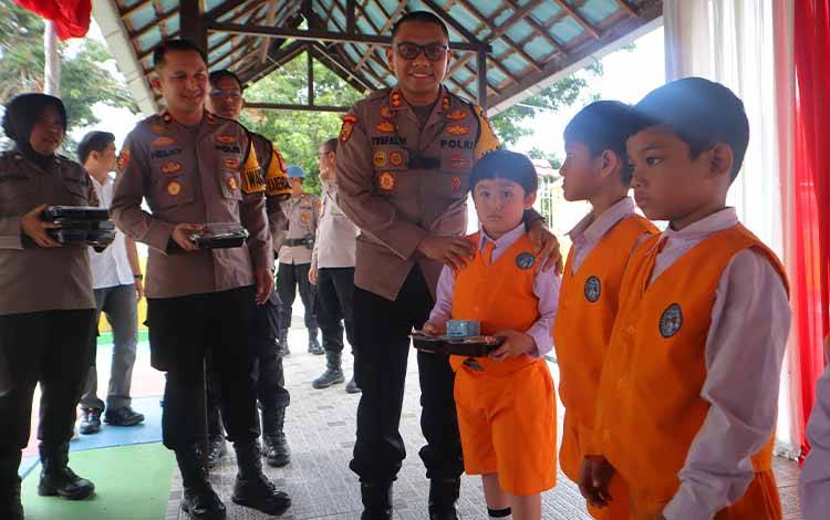 Kapolres Kobar AKBP Yusfandi Usman saat menyerahkan makanan bergizi kepada anak TK Kemala Bhayangkari.