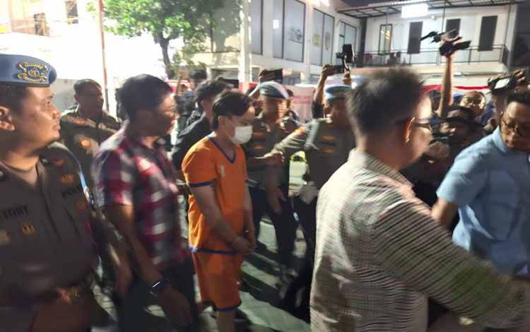 Tersangka berinisial 'I' yang memaksa anak SMAK Gloria 2 untuk bersujud dan menggonggong layaknya anjing digiring aparat ke tahanan Mapolrestabes Surabaya, Kamis (14/11/2024) malam. (ANTARA/HO-Gun)