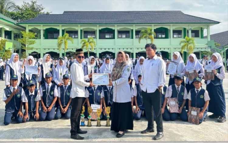 Penyerahan piagam dan piala kepada pelajar MTsN 1 Kapuas yang meraih prestasi di ajang Annual Competition Ke-V Ponpes Al-Muhajirin 2024. (FOTO: IST)