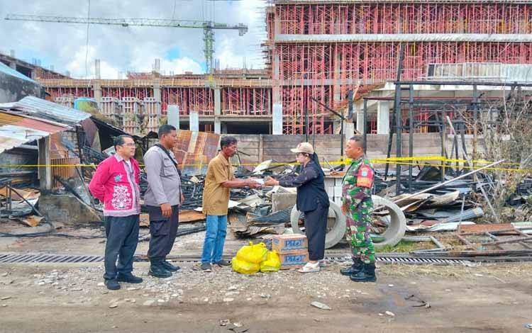 Lurah Langkai Sriwanti saat menyerahkan bantuan kepada warga yang terdampak kebakaran di Gang Maulan (Foto : PATHUR)