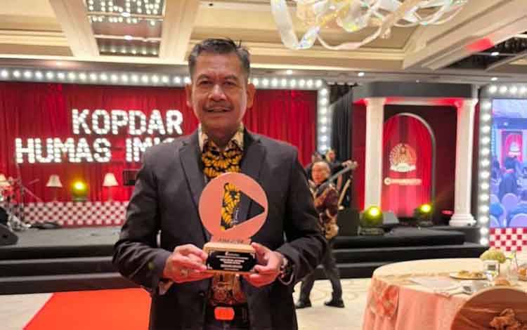 Kepala Kantor Imigrasi Kelas I Non TPI Palangka Raya, Mulyadi menunjukkan piala pada Anugerah Humas Imigrasi di Jakarta, Kamis (29/11/2024). (ANTARA/HO-Kanim Kelas I Non TPI Palangka Raya)