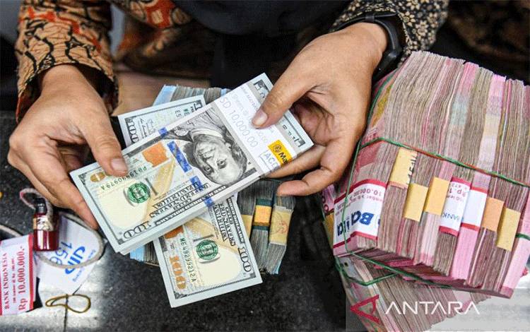 Arisp foto - Petugas menghitung uang pecahan dolar AS dan rupiah di gerai penukaran mata uang asing VIP (Valuta Inti Prima) Money Changer, Jakarta, Jumat (1/3/2024). ANTARA FOTO/Muhammad Adimaja/rwa/aa.