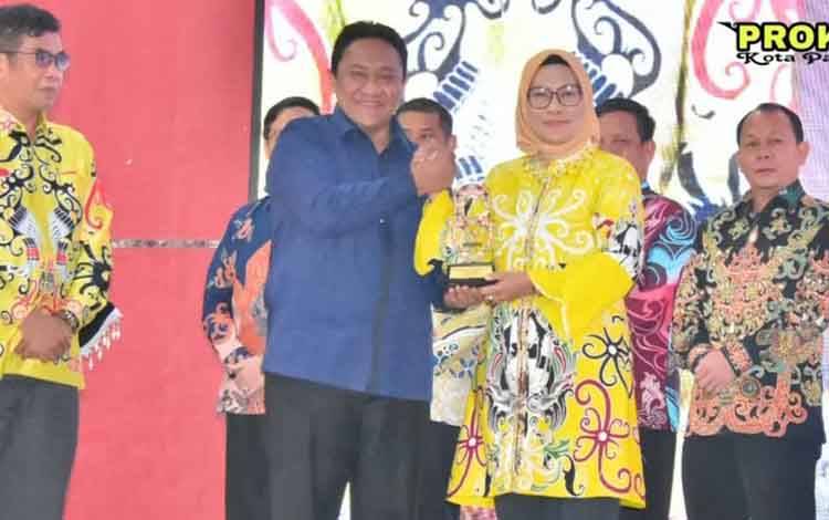 Pj Wali Kota Palangka Raya saat menerima penghargaan keterbukaan informasi badan publik. (FOTO: HUMAS)