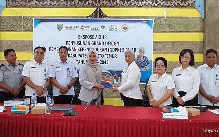 Plt Kepala DP3AKB Barito Timur, Hotmaria Damanik (empat dari kanan), menunjukkan dokumen Grand Design Pembangunan Kependudukan (GDPK) Barito Timur tahun 2025-2025, di Aula Bapplitbangda Barito Timur, Rabu, 11 Desember 2024. (FOTO: IST)