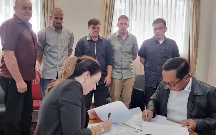Perwakilan Australia, Minister-Counsellor Home Affairs, Regional Director South-East Asia, Lauren Richardson (kiri bawah) dan Direktur Pembinaan Narapidana Direktorat Jenderal Pemasyarakatan RI Erwedi Supriyatno (kanan bawah) menandatangani berkas serah terima pemindahan lima narapidana kasus Bali Nine di Bandara Internasional I Gusti Ngurah Rai, Bali, Minggu (15/12/2024). ANTARA/HO-Kemenko Kumham Imipas