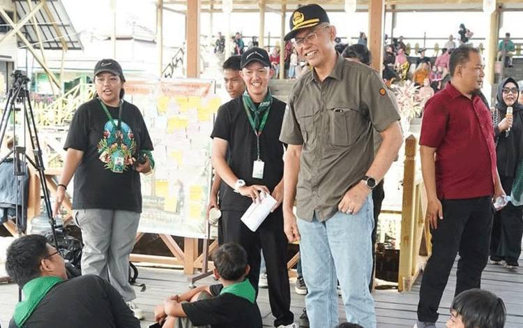 Pj Wali Kota Palangka Raya, Akhmad Husain berbincang dengan anak-anak saat pembukaan Festival Anak Sabangau. (FOTO: HUMAS)