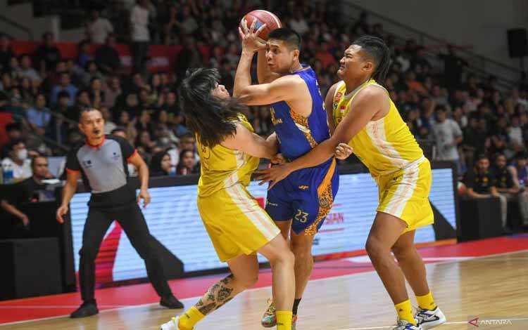 Pebasket Satria Muda Pertamina Jakarta Avan Seputra (tengah) mendapatkan pengawalan ketat dari pebasket Ksatria Bengawan Solo Bryan Adha Elang Praditya (kanan) dan Esha Lapian (kiri) dalam laga penyisihan Grup A IBL All Indonesian Piala Menpora di Hall Basket Senayan, Gelora Bung Karno, Jakarta, Minggu (22/9/2024). ANTARA FOTO/Hafidz Mubarak A/app/Spt