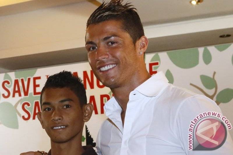 Pesohor sepak bola dunia yang menjadi Duta Mangrove, Cristiano Ronaldo (kanan) berfoto bersama anak yang selamat dari tsunami Aceh tahun 2004, Martunis (kiri) seusai memberi keterangan di Kuta, Bali, Rabu (26/6). Kehadiran bintang sepak bola yang dijuluki CR7 itu di Bali sebagai Duta Mangrove tersebut ditargetkan dapat membangkitkan kesadaran masyarakat untuk peduli lingkungan khususnya penyelamatan hutan bakau di Indonesia. (ANTARA FOTO/Nyoman Budhiana)