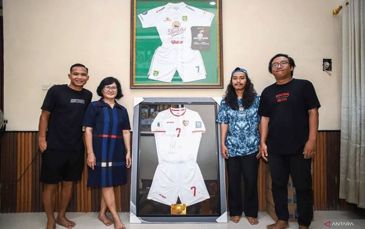 Dari kiri ke kanan - Kakak kedua Marselino Ferdinan Oktafianus Fernando, Ibu Marselino Sudarwiyani, Rizal sebagai perwakilan pemenang, dan Ketua Surabaya Jersey Community (SJC) Yudha Mustopo, di kediaman Marselino Ferdinan di daerah Surabaya Barat, Sabtu (4/1/2025). Ini merupakan acara penyerahan jersey lelang Marselino Ferdinan melawan Arab Saudi pada putaran ketiga kualifikasi Piala Dunia 2026 kepada pemenang yang dilepas dengan nilai Rp100.927.000. (ANTARA/HO-Surabaya Jersey Community)