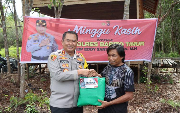 Kapolres Barito Timur AKBP Eddy Santoso menyerahkan bantuan barang kebutuhan pokok kepada masyarakat dalam bakti sosial di kawasan Danau Dayu, Minggu, 12 Januari 2024. (FOTO: IST)