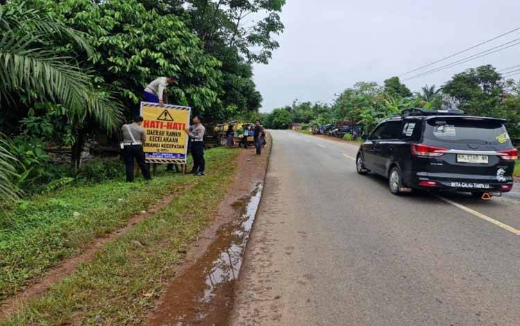 Anggota Satlantas Polres Kotim memasang spanduk peringatan waspada kecelakaan di Jalan Tjilik Riwut, Kecamatan Cempaga, Kabupaten Kotim. (FOTO: IST)